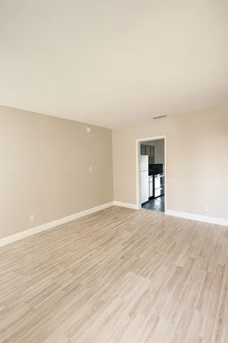 a view of empty room with wooden floor