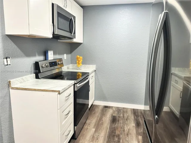 a kitchen with a sink a microwave and refrigerator