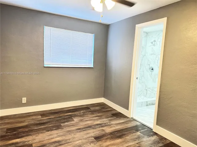 a view of a room with wooden floor and a ceiling fan