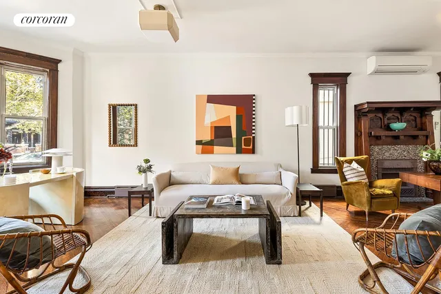 a living room with furniture a rug potted plant a mirror and a large window