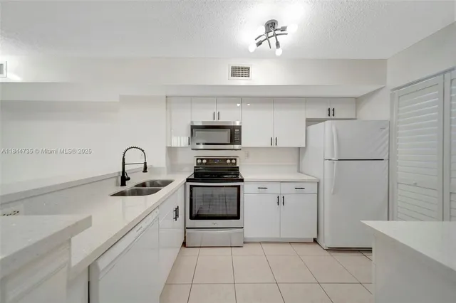 a kitchen with white cabinets and white appliances