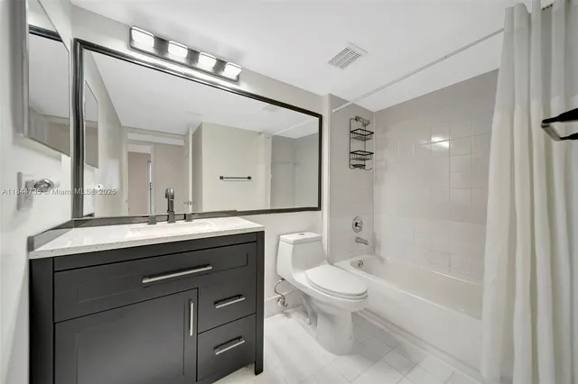 a spacious bathroom with a granite countertop toilet a sink and a mirror