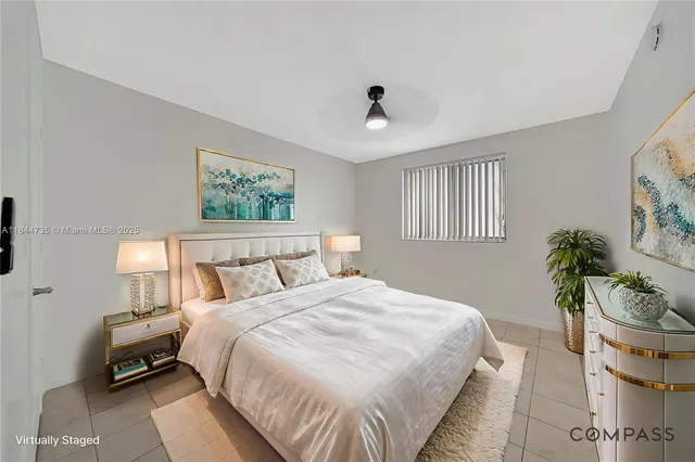 a bedroom with bed and a potted plant