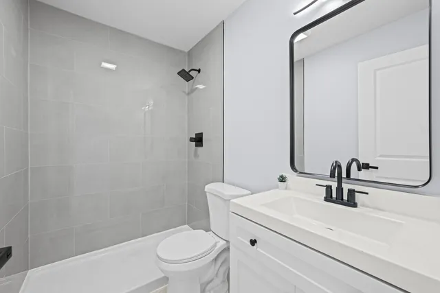 a bathroom with a sink a toilet and shower