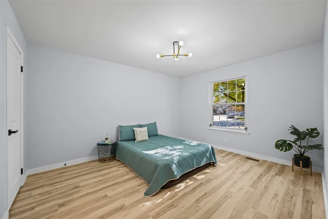 a bedroom with a bed and a chandelier