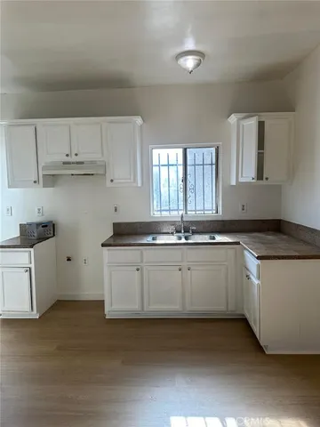 a kitchen with granite countertop white cabinets and white appliances