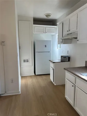 a kitchen with cabinets and wooden floor