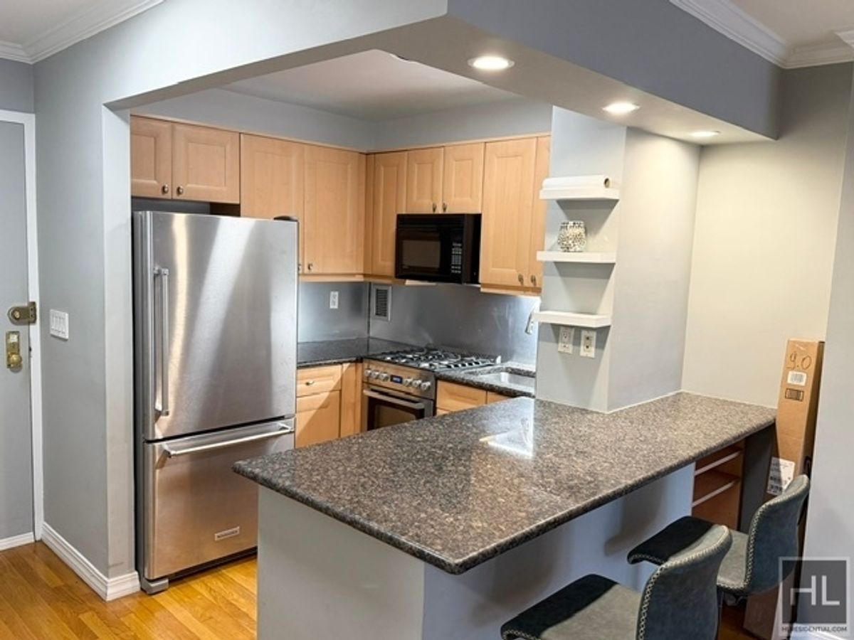 333 East 34th Street, Unit 9O Manhattan, NY 10016 - Photo 2 of 8 a kitchen with stainless steel appliances granite countertop a refrigerator a stove and a sink
