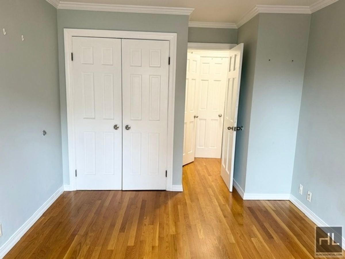 333 East 34th Street, Unit 9O Manhattan, NY 10016 - Photo 6 of 8 an empty room with wooden floor and closet