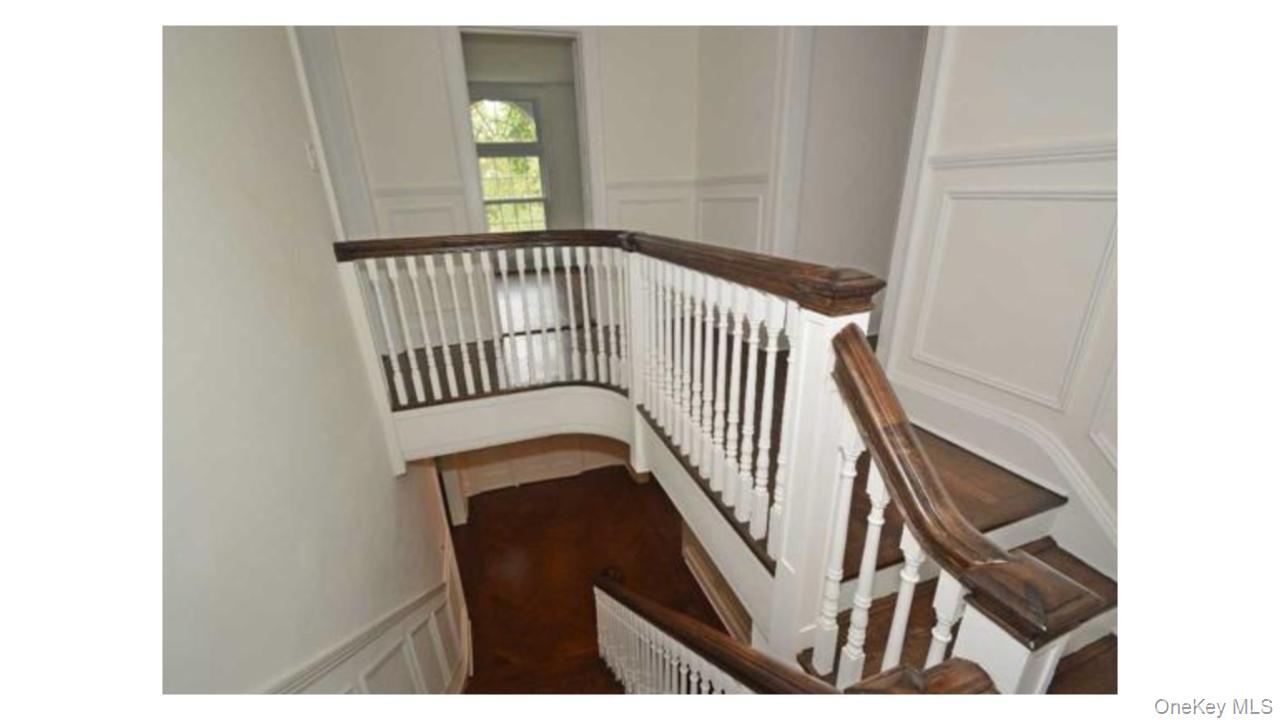 2 Arleigh Road Great Neck, NY 11021 - Photo 4 of 22 Hardwood stairs with white balusters and dark wood handrails