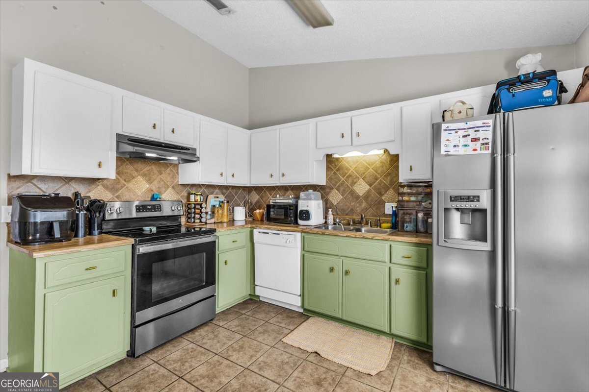 1244 Chinook Way Hinesville, GA 31313 - Photo 12 of 27 a kitchen with stainless steel appliances granite countertop a refrigerator sink and stove