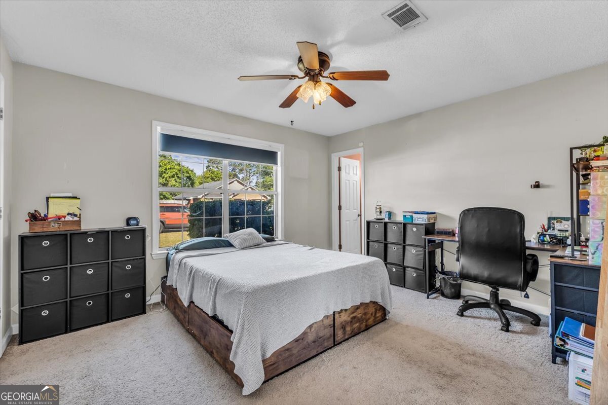 1244 Chinook Way Hinesville, GA 31313 - Photo 14 of 27 a bedroom with a bed and a chandelier