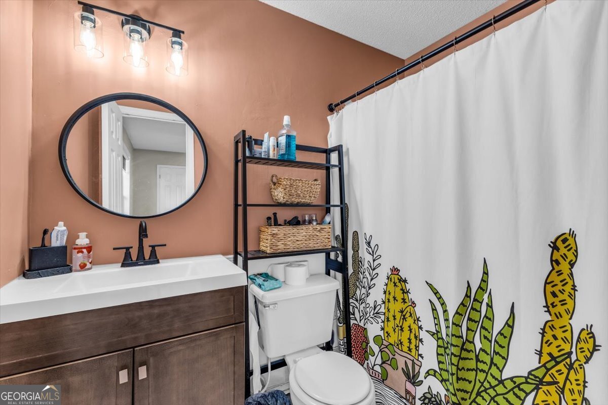 1244 Chinook Way Hinesville, GA 31313 - Photo 16 of 27 a bathroom with a toilet sink and mirror