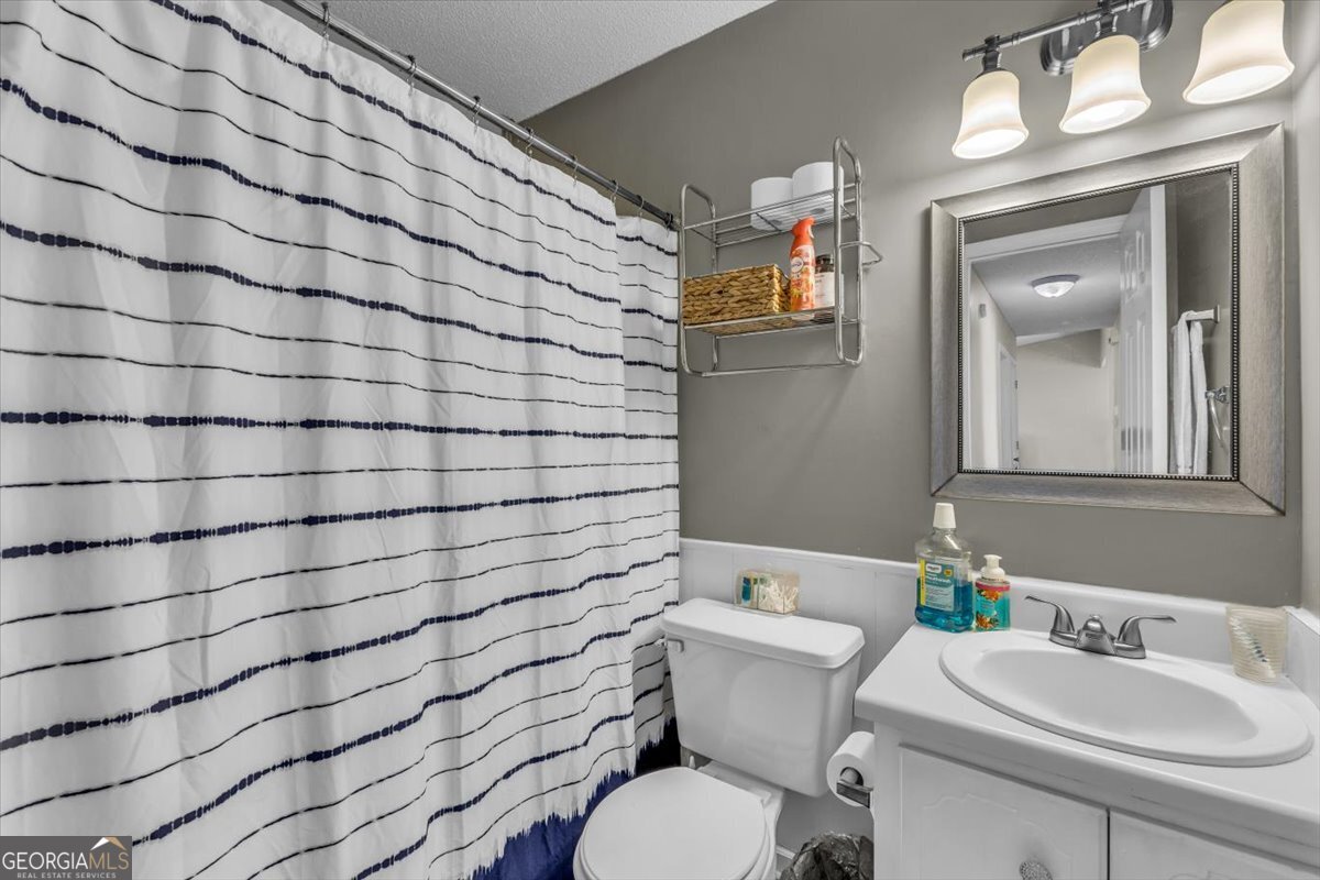 1244 Chinook Way Hinesville, GA 31313 - Photo 22 of 27 a bathroom with a sink mirror vanity and toilet