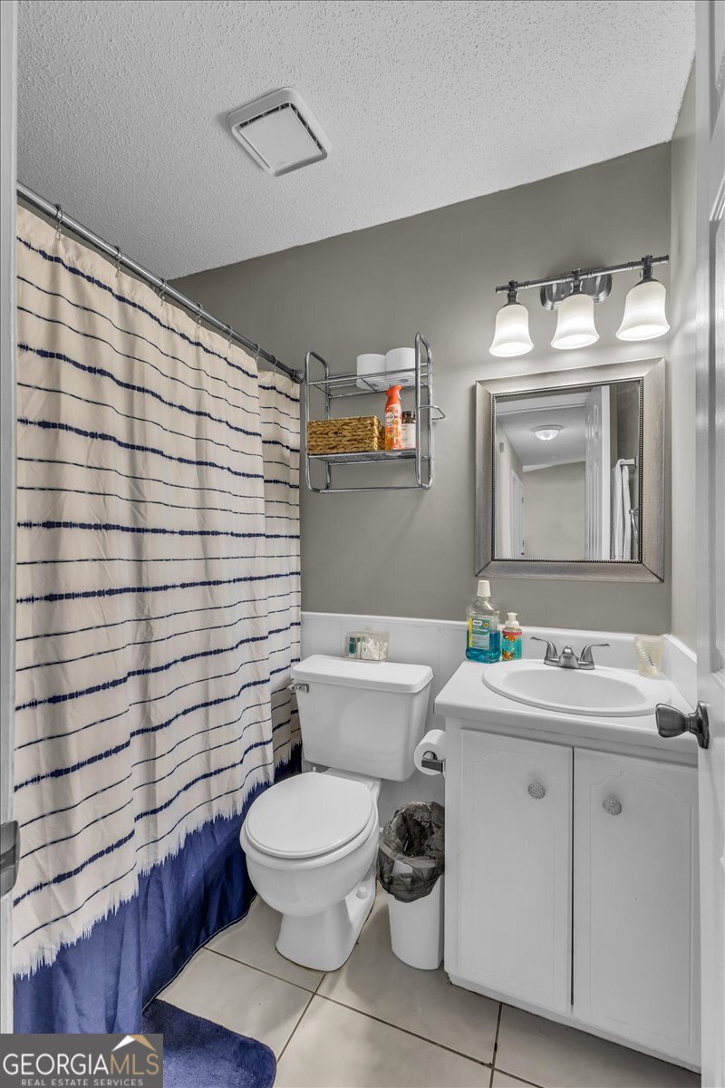 1244 Chinook Way Hinesville, GA 31313 - Photo 23 of 27 a bathroom with a toilet a sink and mirror