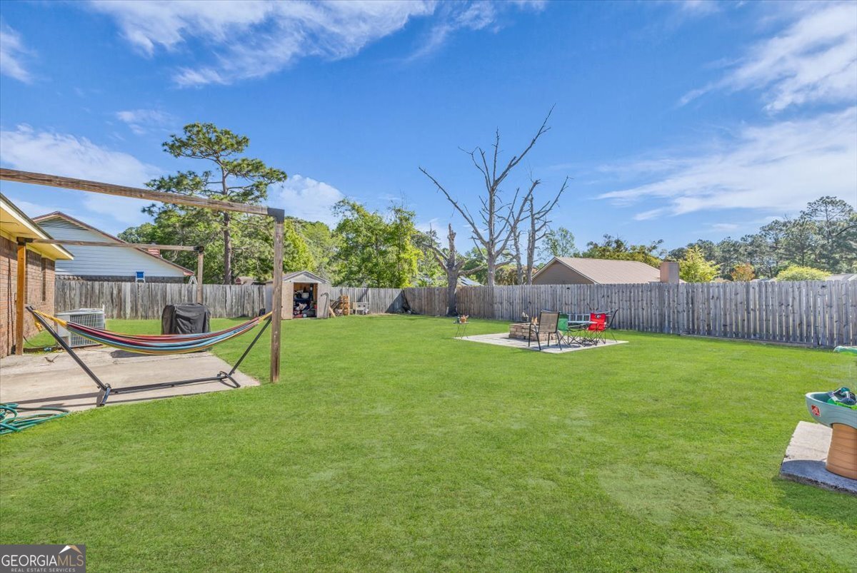 1244 Chinook Way Hinesville, GA 31313 - Photo 26 of 27 a view of a backyard with a slide