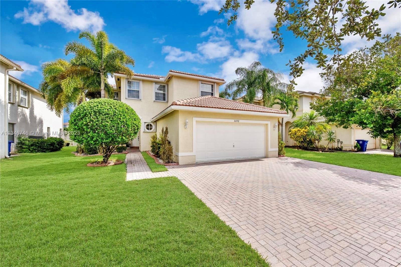 16392 Southwest 29th Street Miramar, FL 33027 - Photo 1 of 30 a front view of a house with a yard and garage