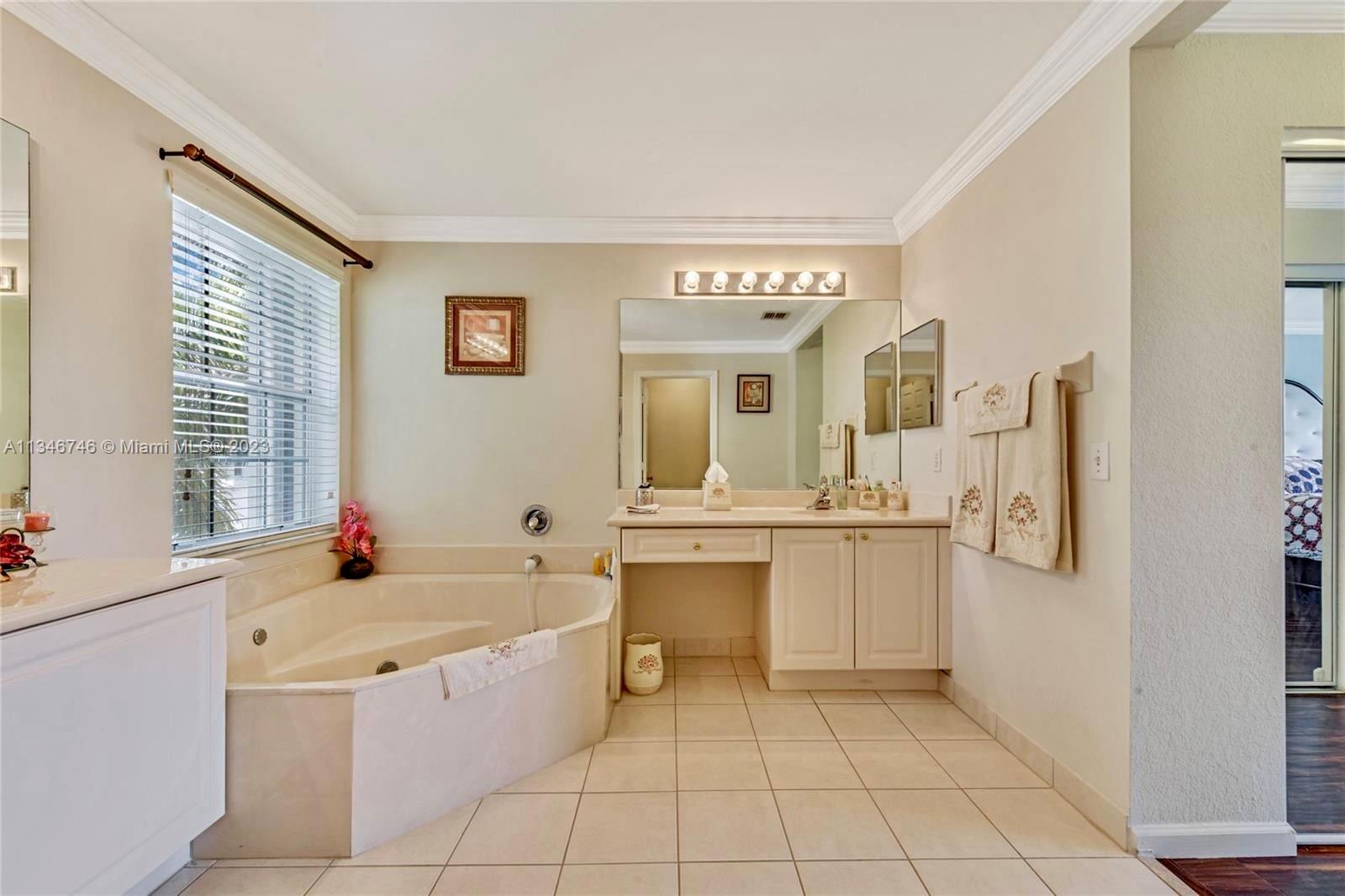 16392 Southwest 29th Street Miramar, FL 33027 - Photo 11 of 30 a large bathroom with a granite countertop sink mirror and a bathtub