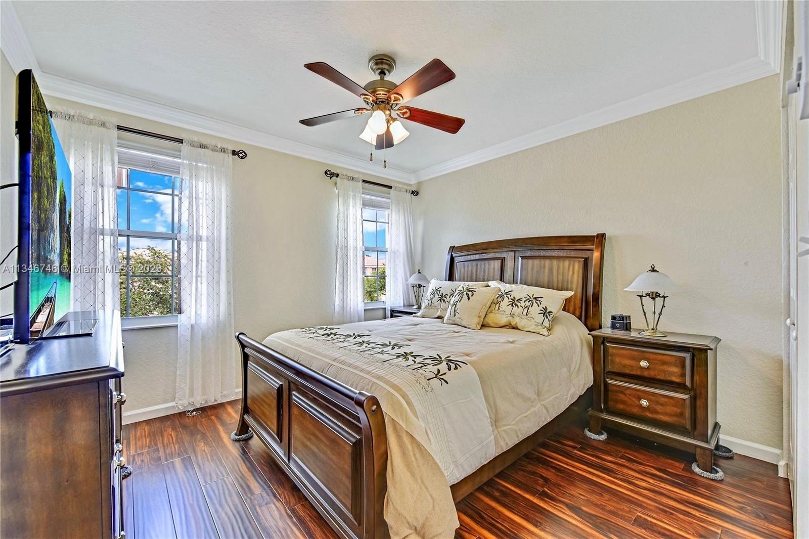 16392 Southwest 29th Street Miramar, FL 33027 - Photo 12 of 30 a bedroom with a bed and a bookshelf with wooden floor