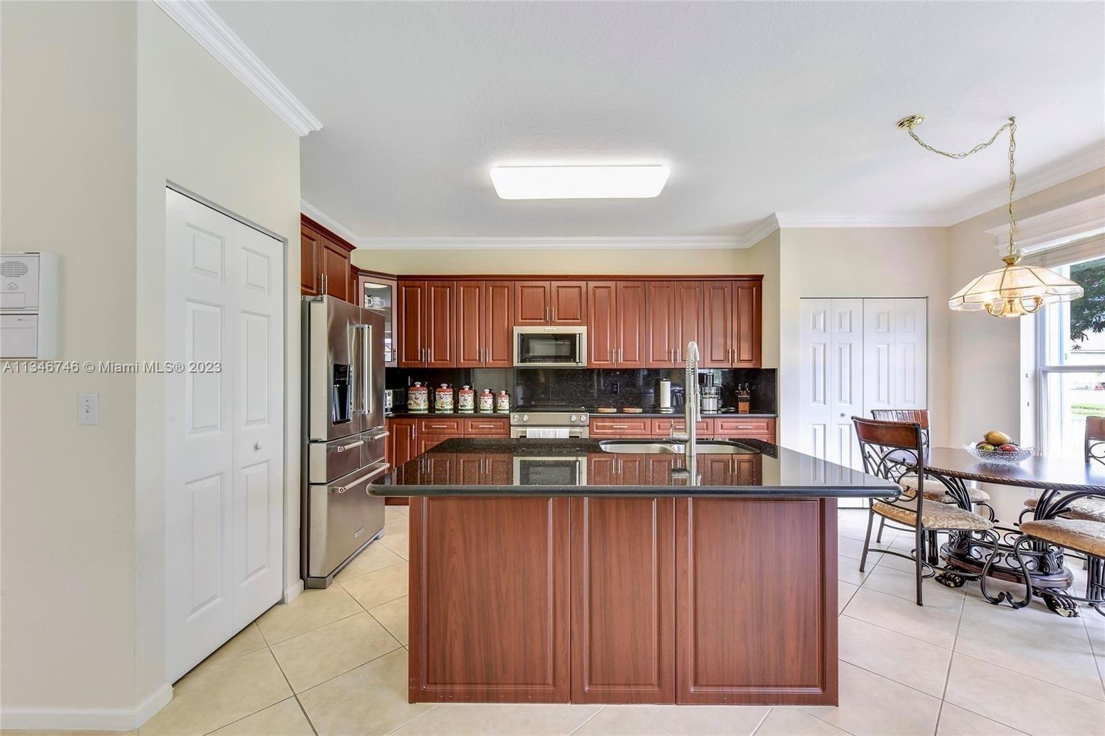 16392 Southwest 29th Street Miramar, FL 33027 - Photo 22 of 30 a view of a kitchen with kitchen island stainless steel appliances a sink window and cabinets