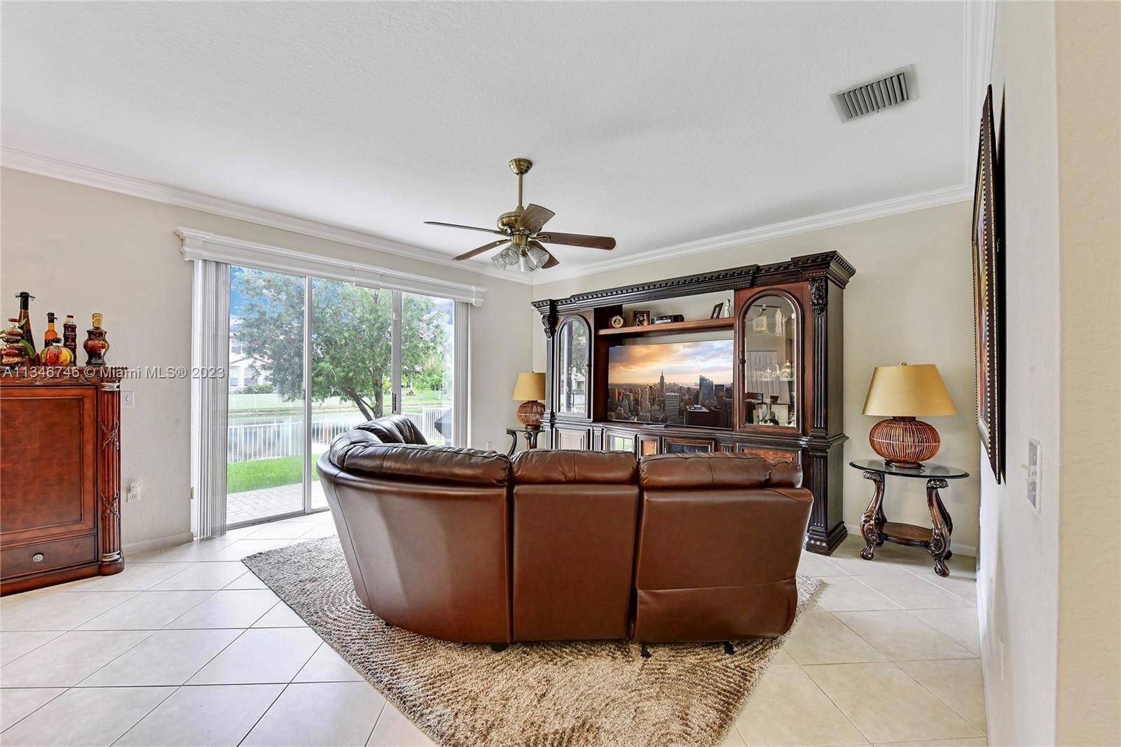16392 Southwest 29th Street Miramar, FL 33027 - Photo 23 of 30 a living room with furniture a flat screen tv and a large window
