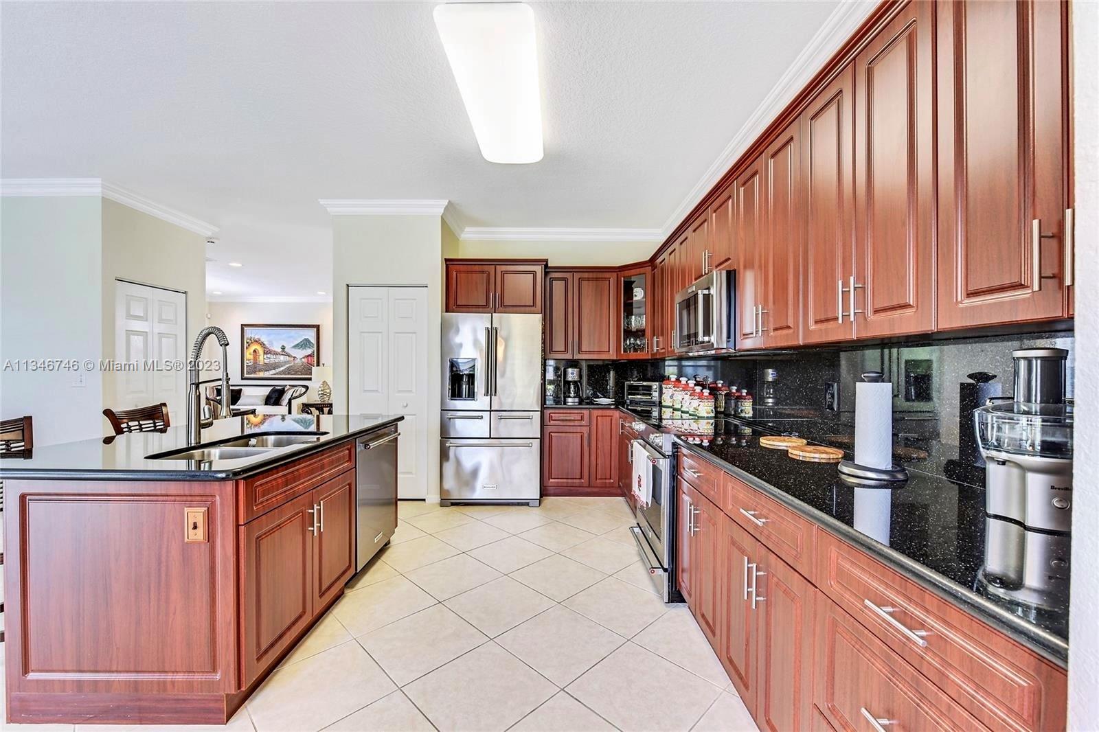 16392 Southwest 29th Street Miramar, FL 33027 - Photo 4 of 30 a kitchen with stainless steel appliances granite countertop a stove top oven a sink dishwasher and a refrigerator