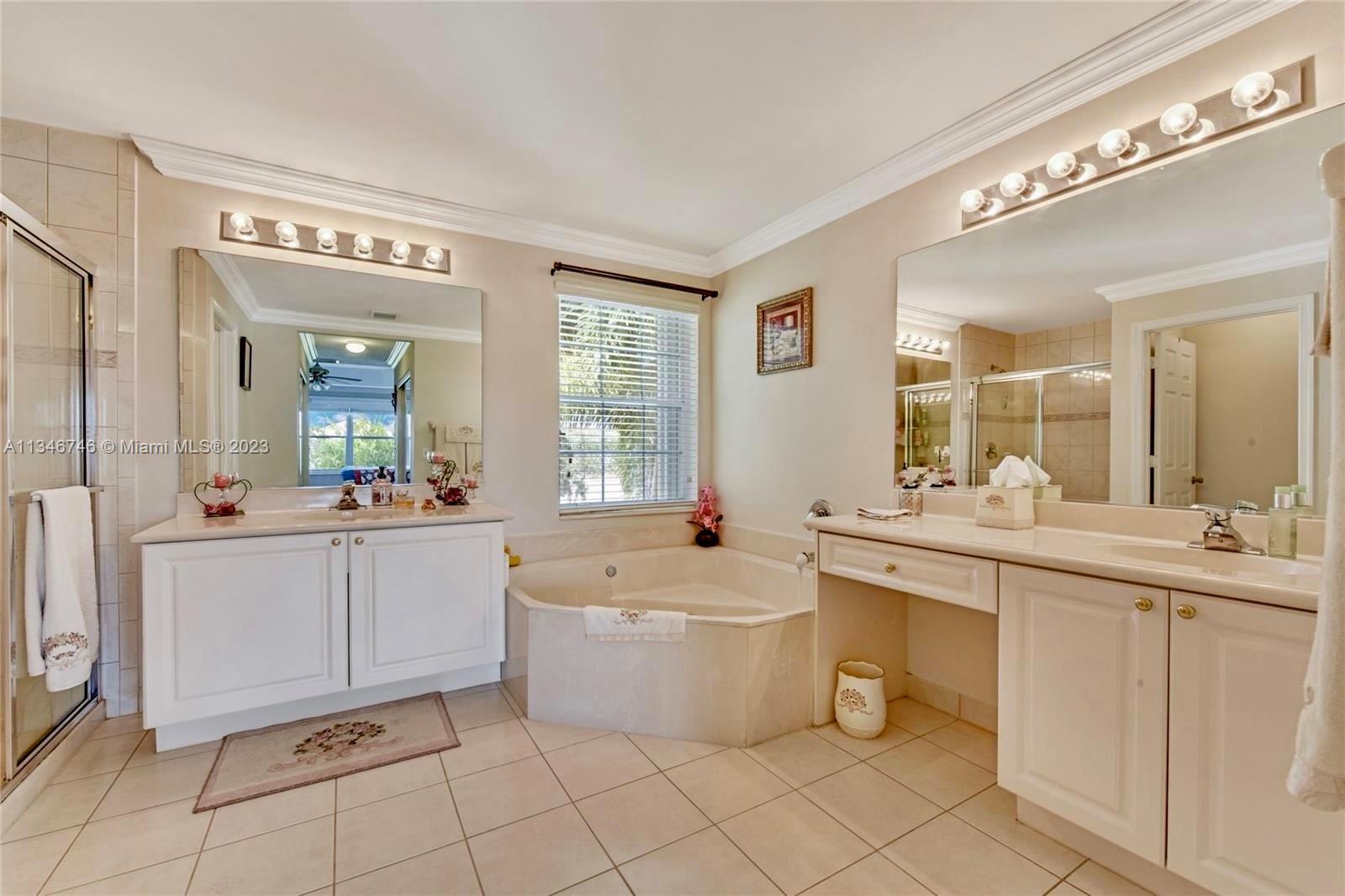 16392 Southwest 29th Street Miramar, FL 33027 - Photo 10 of 30 a large white bathroom with a granite countertop sink and a mirror