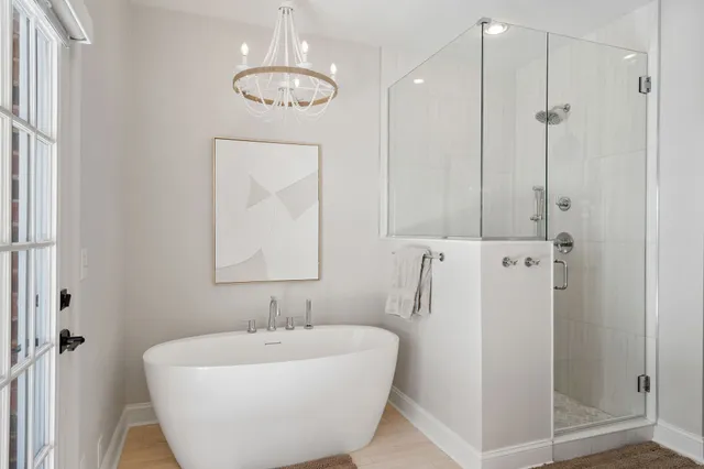 a bathroom with a white bath tub a sink and a mirror