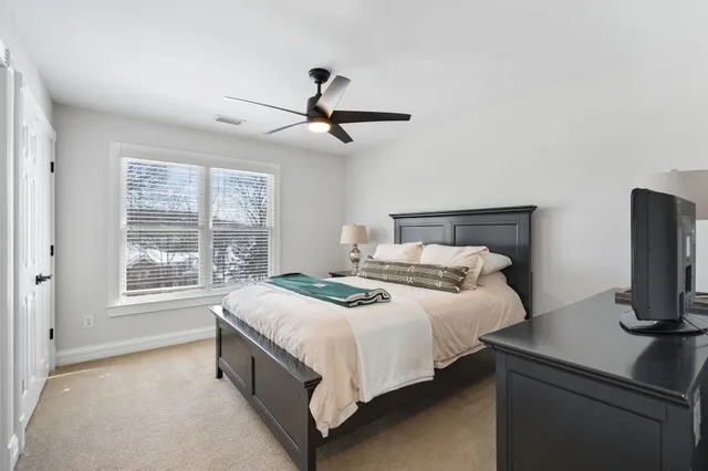 a bedroom with a bed and a tv on the dresser