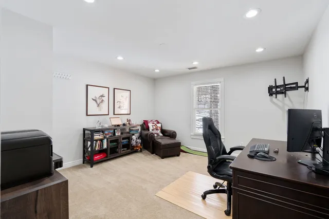 a view of a workspace with furniture and a window