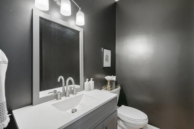 a bathroom with a toilet a sink and mirror
