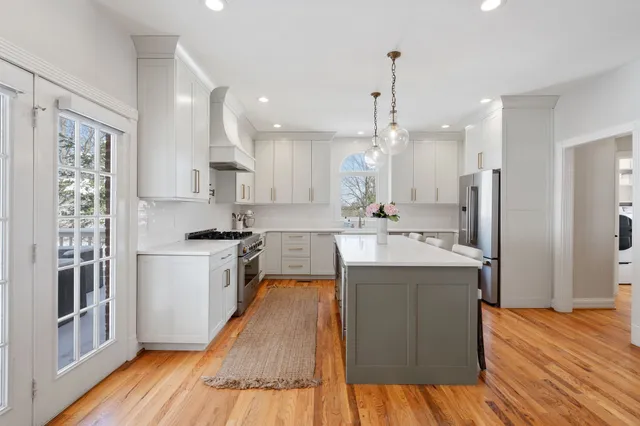 a kitchen with kitchen island sink stove and refrigerator