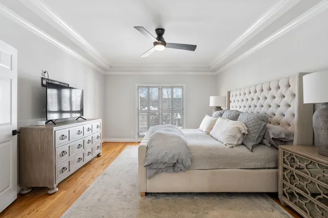 a spacious bedroom with a large bed and a flat tv screen on dresser