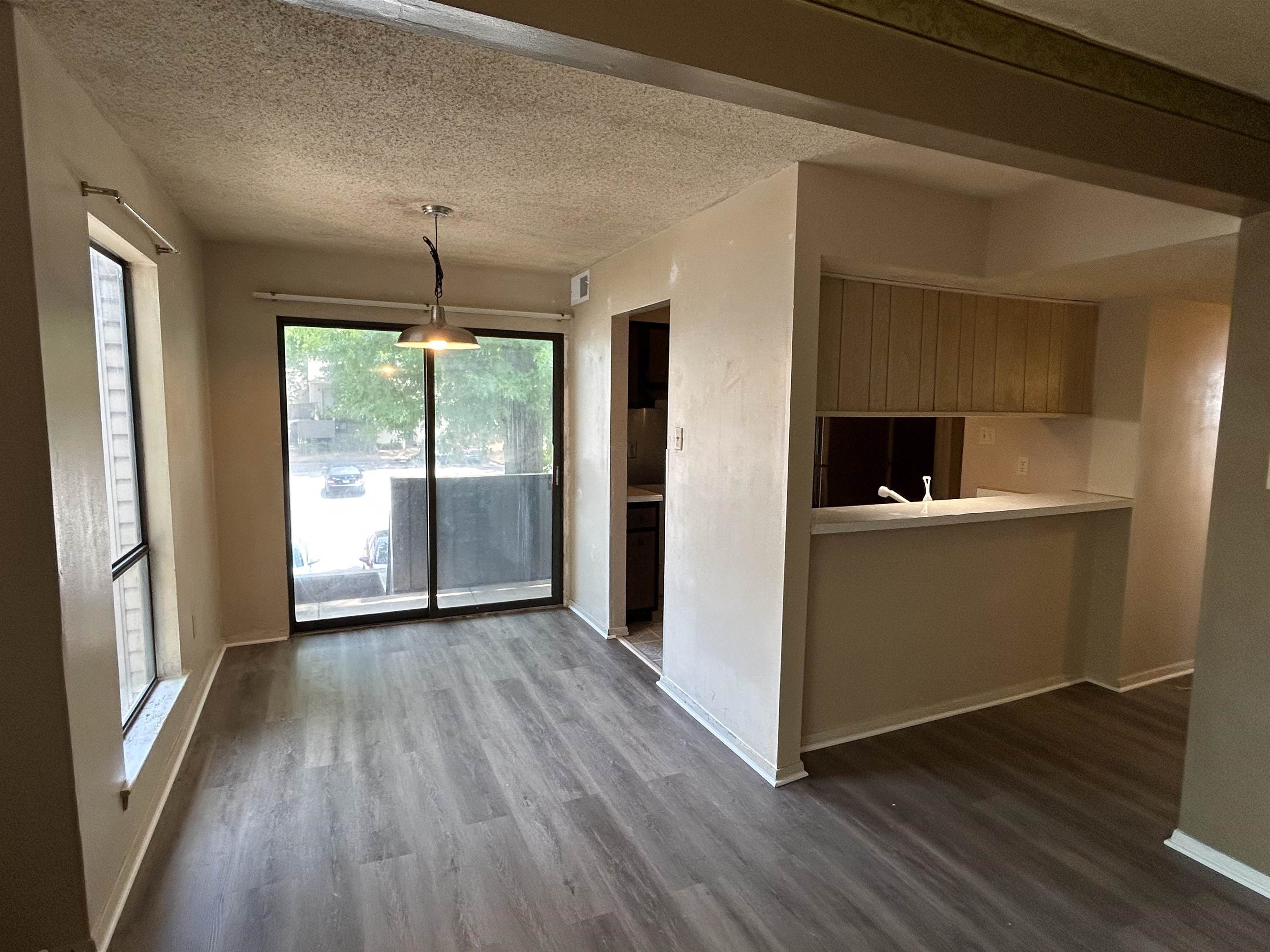 2800 Clarke Road, Unit 2 Memphis, TN 38115 - Photo 4 of 18 Dining area featuring wood-finish flooring, a contemporary pendant light fixture, and a sliding glass door providing exterior access