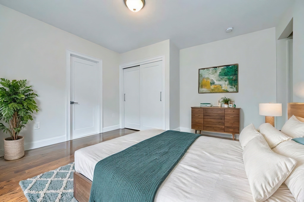 63 Bradford Road, Unit B Watertown, MA 02472 - Photo 11 of 24 a bedroom with a bed and a potted plant