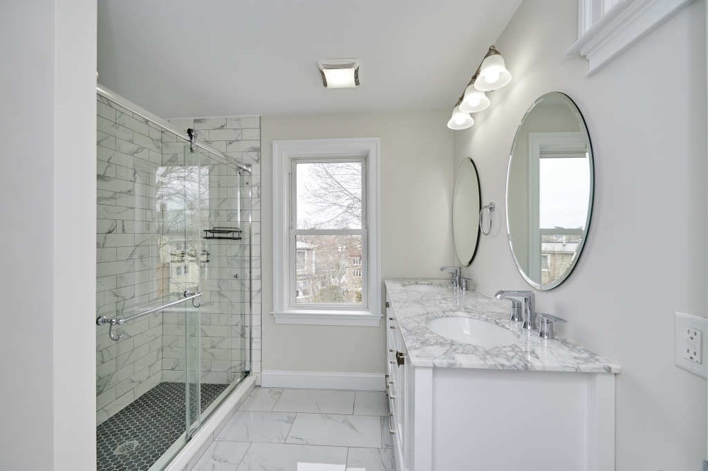 63 Bradford Road, Unit B Watertown, MA 02472 - Photo 14 of 24 a bathroom with a granite countertop sink a mirror and a shower