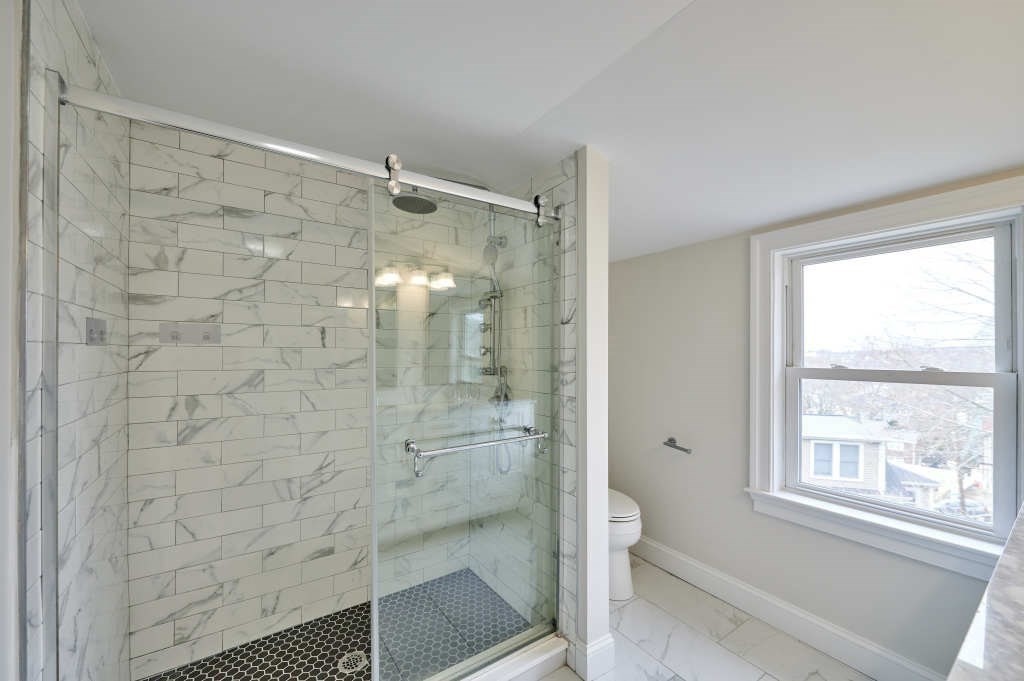 63 Bradford Road, Unit B Watertown, MA 02472 - Photo 15 of 24 a bathroom with a glass shower door