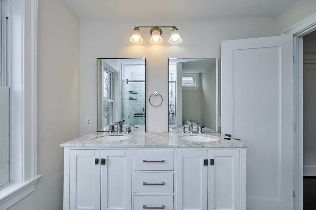 63 Bradford Road, Unit B Watertown, MA 02472 - Photo 16 of 24 a bathroom with a double vanity sink and a mirror