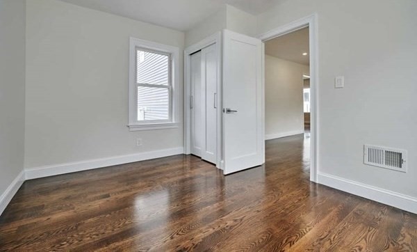 63 Bradford Road, Unit B Watertown, MA 02472 - Photo 19 of 24 an empty room with wooden floor and windows