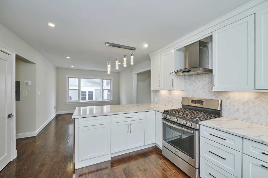 63 Bradford Road, Unit B Watertown, MA 02472 - Photo 4 of 24 a kitchen with granite countertop a sink cabinets and stainless steel appliances