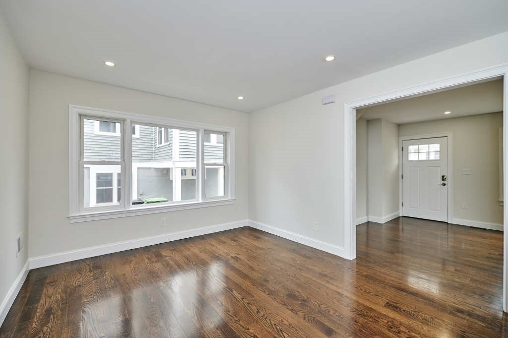 63 Bradford Road, Unit B Watertown, MA 02472 - Photo 9 of 24 a view of an empty room with wooden floor and windows