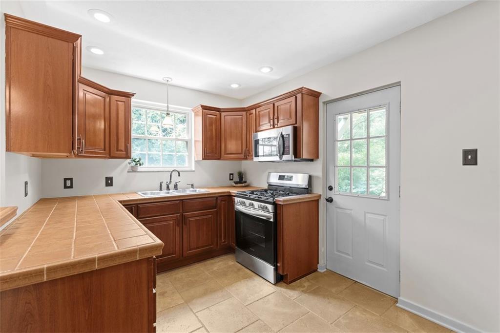 21 Bryn Mawr Road Pittsburgh, PA 15221 - Photo 11 of 42 a kitchen with stainless steel appliances granite countertop a sink stove and refrigerator