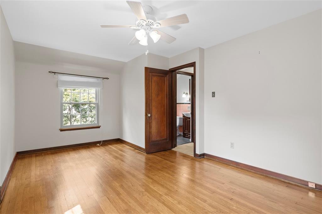 21 Bryn Mawr Road Pittsburgh, PA 15221 - Photo 18 of 42 an empty room with wooden floor chandelier fan and windows