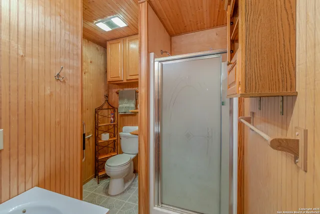 a bathroom with a granite countertop toilet a sink and shower