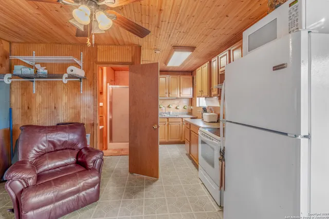 a kitchen with a refrigerator and white cabinets