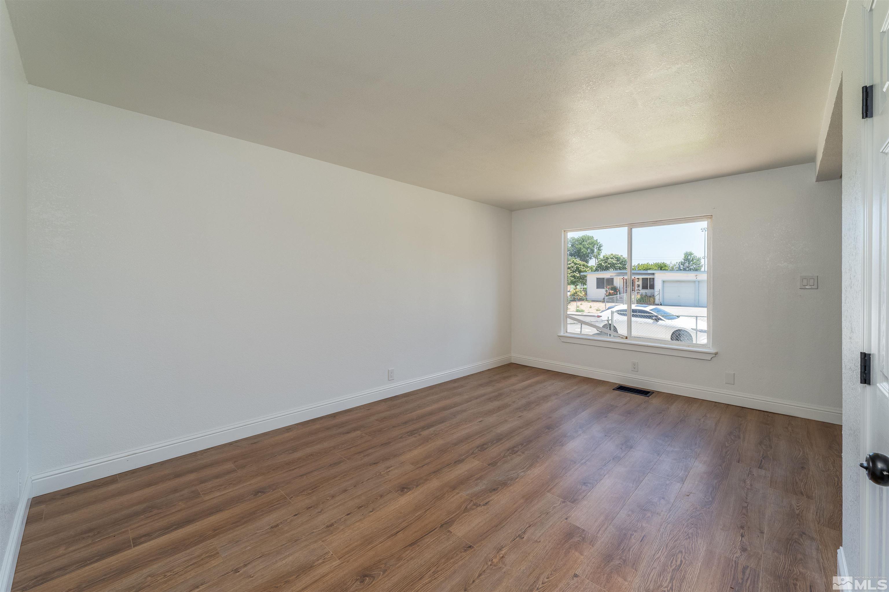1815 Radcliffe Drive Reno, NV 89502 - Photo 6 of 22 an empty room with wooden floor and window
