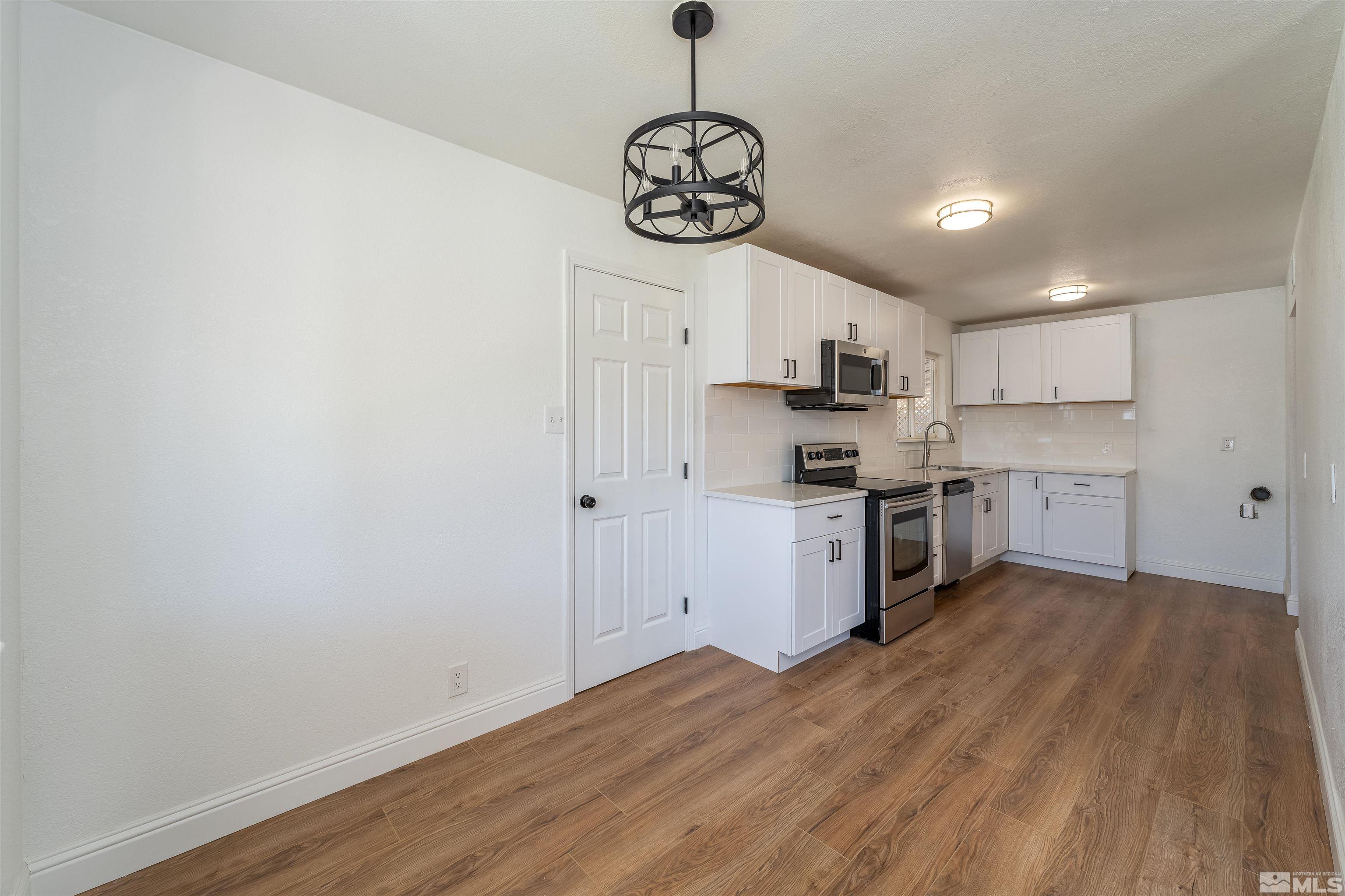 1815 Radcliffe Drive Reno, NV 89502 - Photo 7 of 22 a kitchen with stainless steel appliances granite countertop a stove top oven a refrigerator a sink and dishwasher with wooden floor