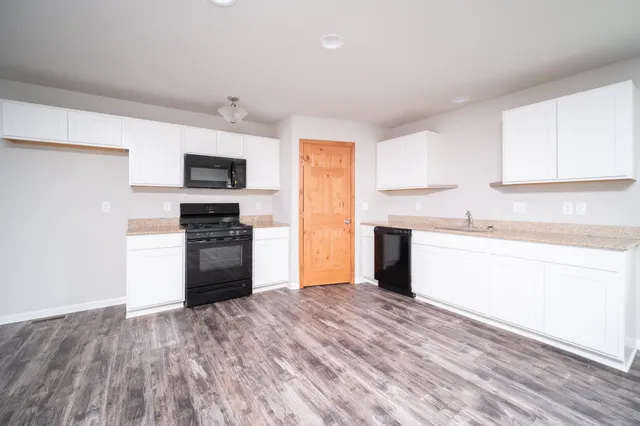 a kitchen with stainless steel appliances granite countertop a refrigerator and a stove top oven