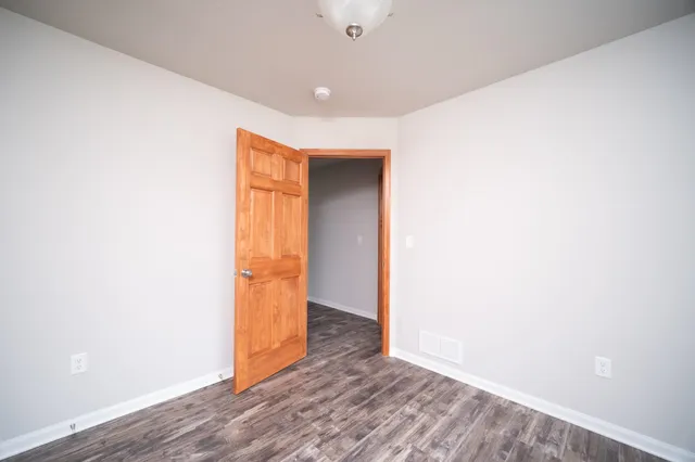 a view of an empty room with wooden floor