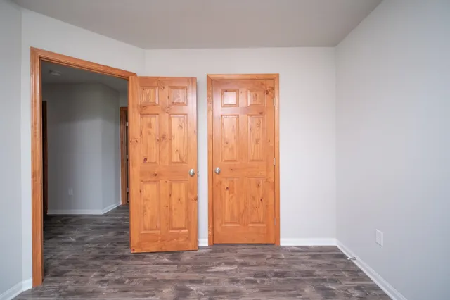an empty room with wooden floor and closet area